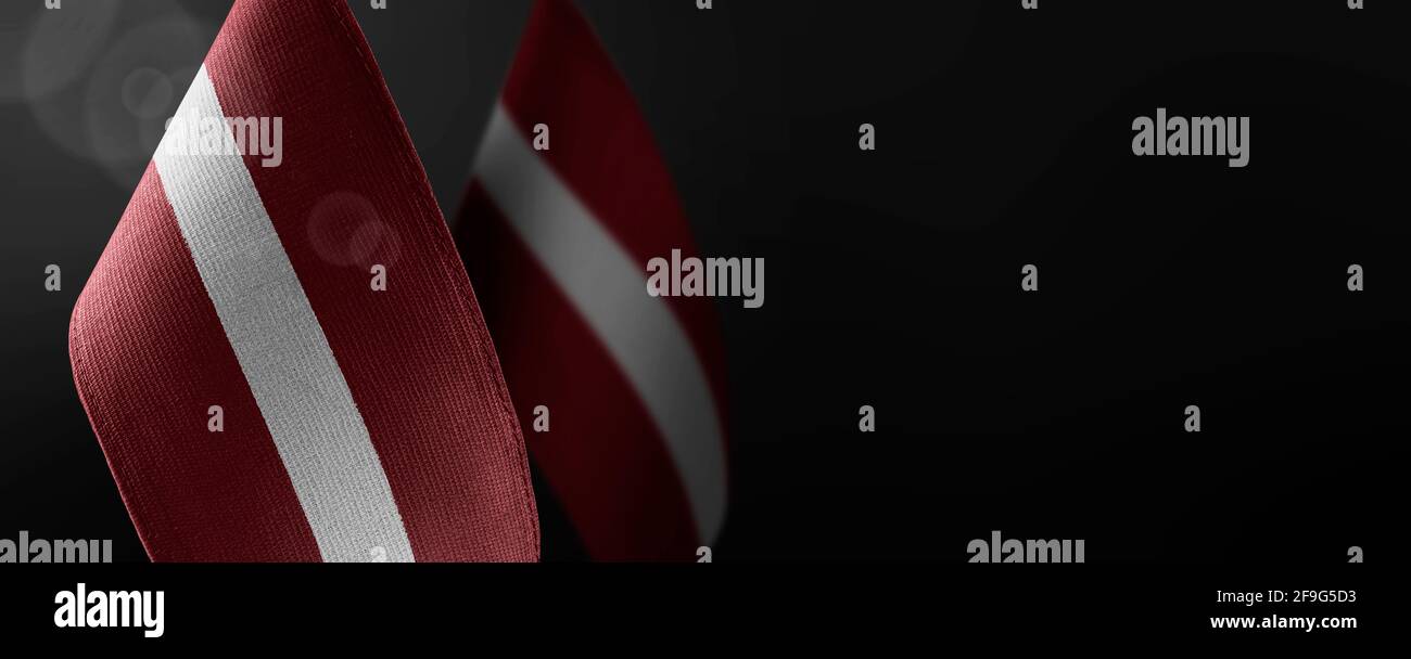 Small national flags of the Latvia on a dark background Stock Photo