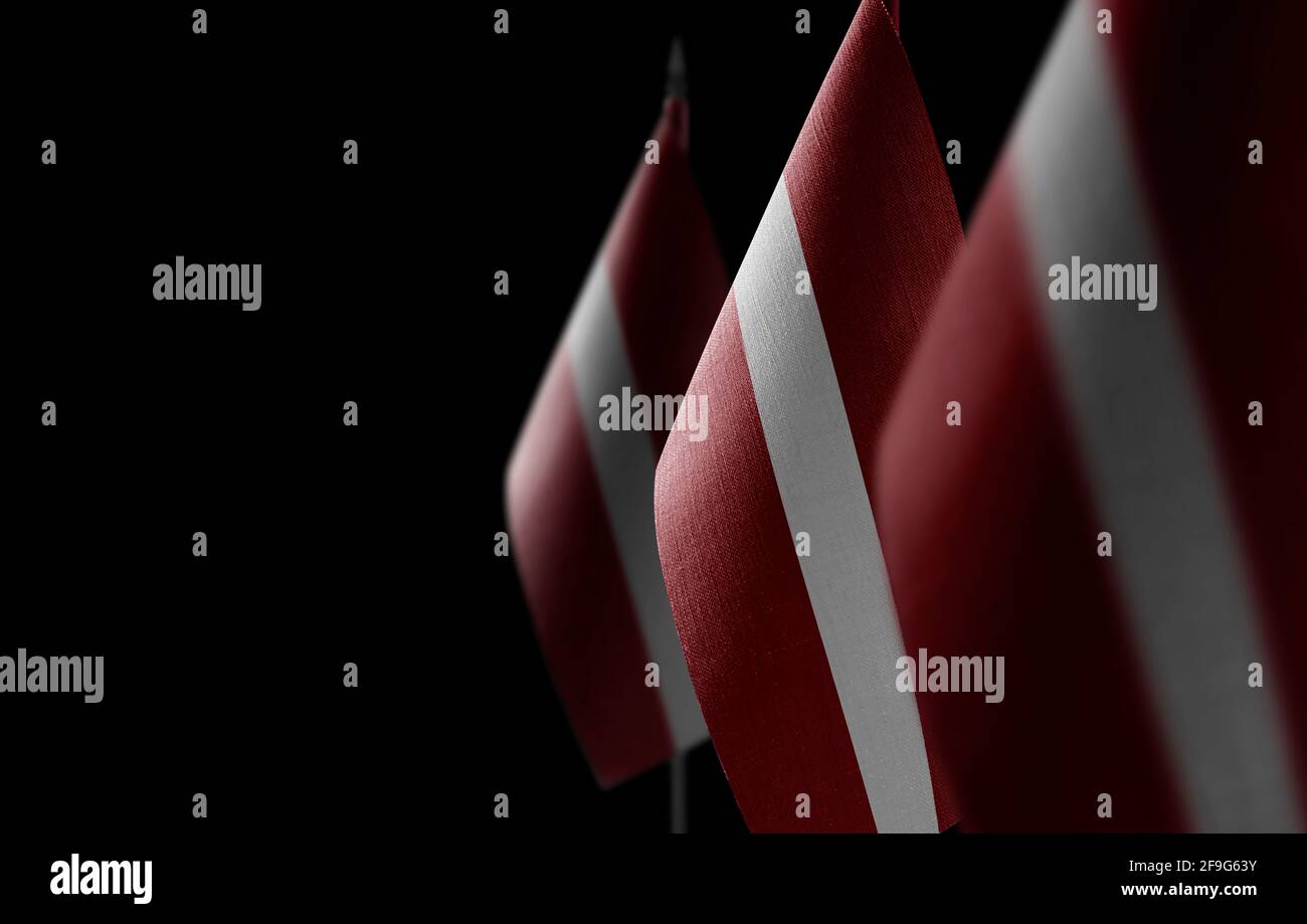 Small national flags of the Latvia on a black background Stock Photo