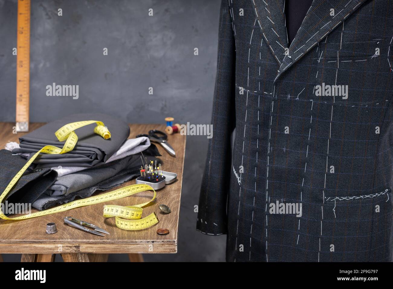 suit jacket on male tailor mannequin and sewing tools, creative concept ...