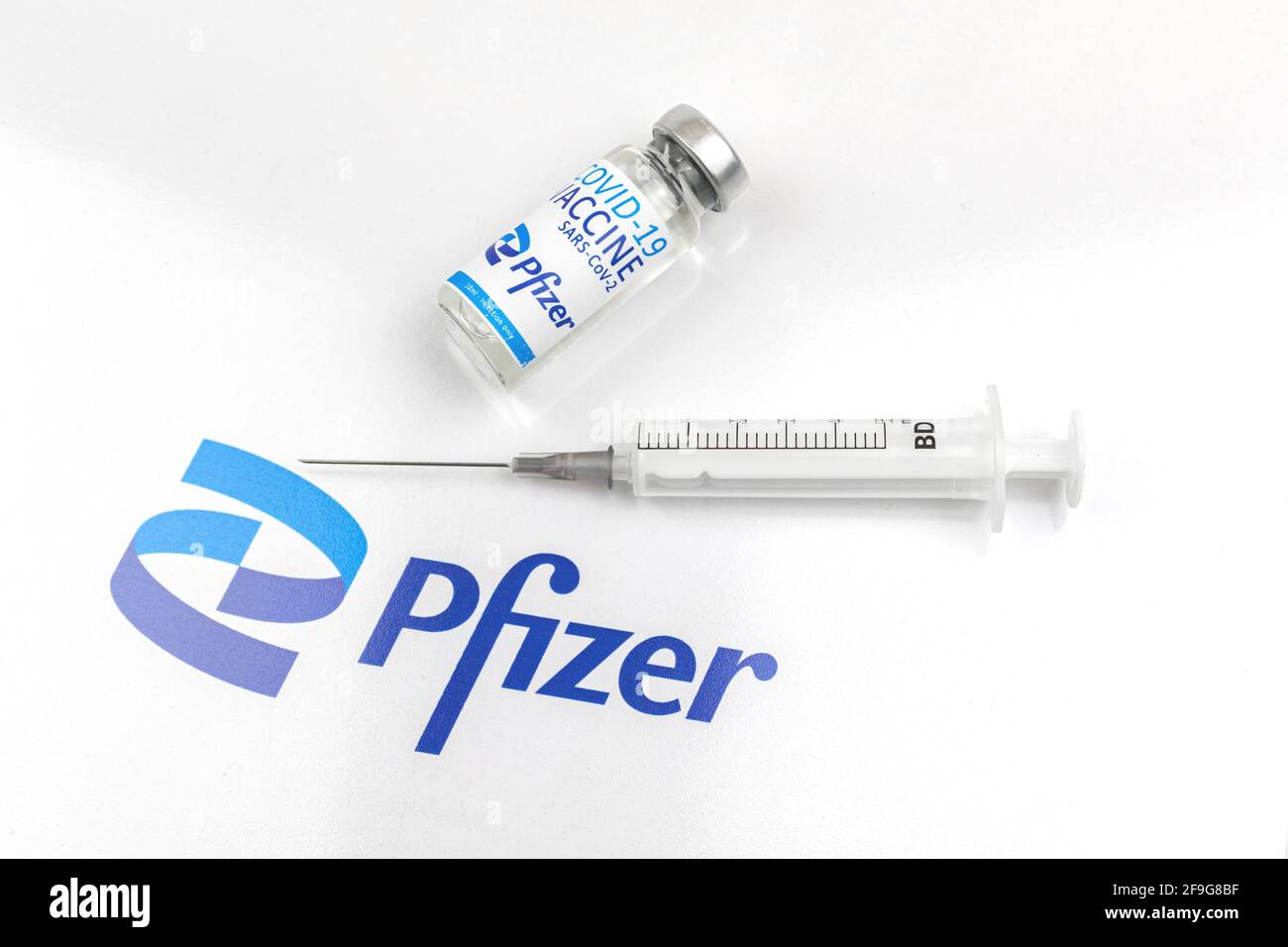 Kharkov, Ukraine - April 18, 2021: Coronavirus prevention and vaccination by using Pfizer vaccince vial and syringe, injection concept, white backgrou Stock Photo