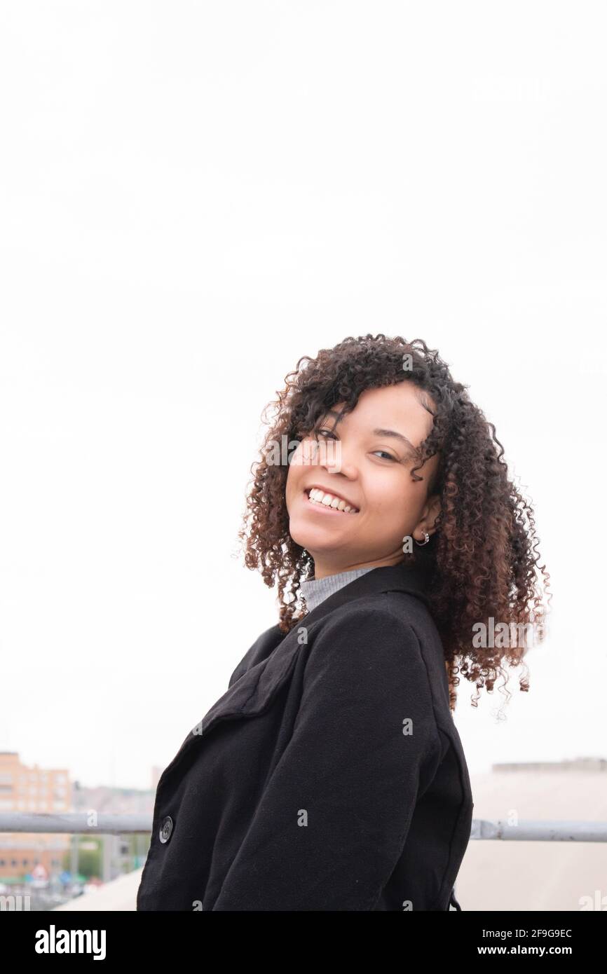 Smiling young black woman with curly hair looking straight at the ...