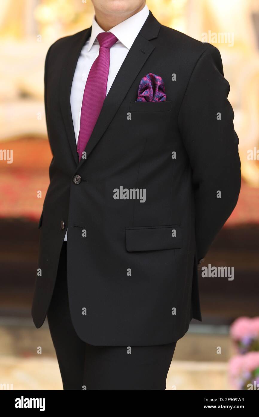 A guy a black suit shirt purple and pocket square side posing Stock Photo -