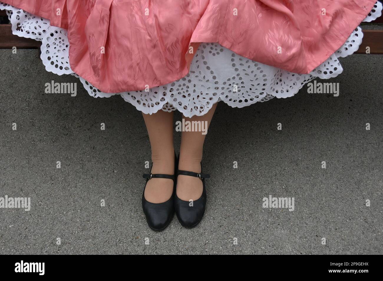A closeup of a female wearing old petticoat hand-embroidered cotton under a pink dress Stock Photo