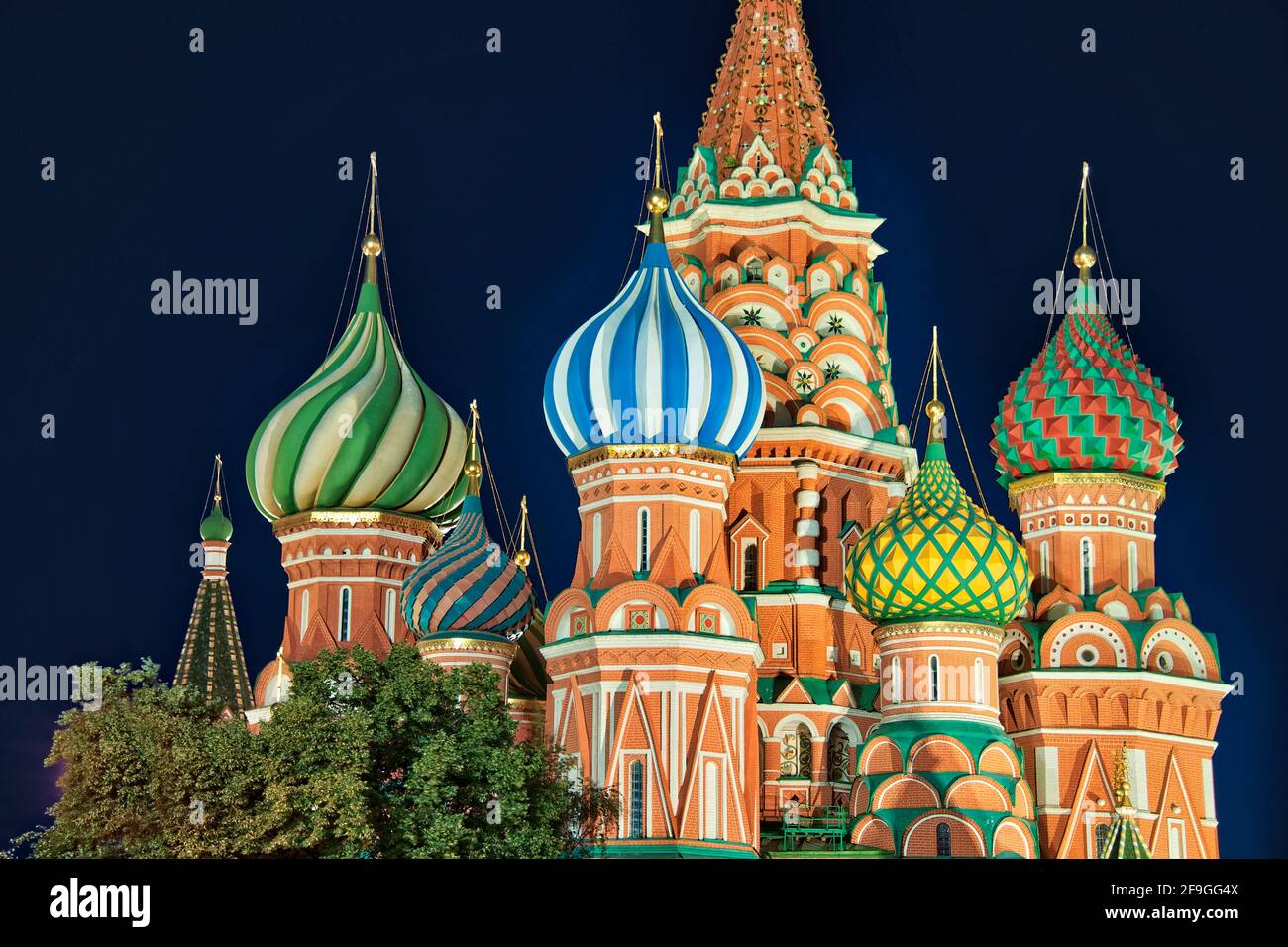= St. Basil’s Domes in the Summer Dusk =  Beautiful red brick towers and multicolored onion domes of Saint Basil's Cathedral at dusk in the summer eve Stock Photo