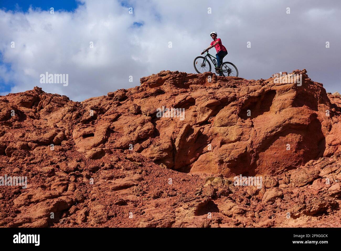 Extreme downhill biker on the edge of red rocks in Timna Park, Eilat, Israel Stock Photo