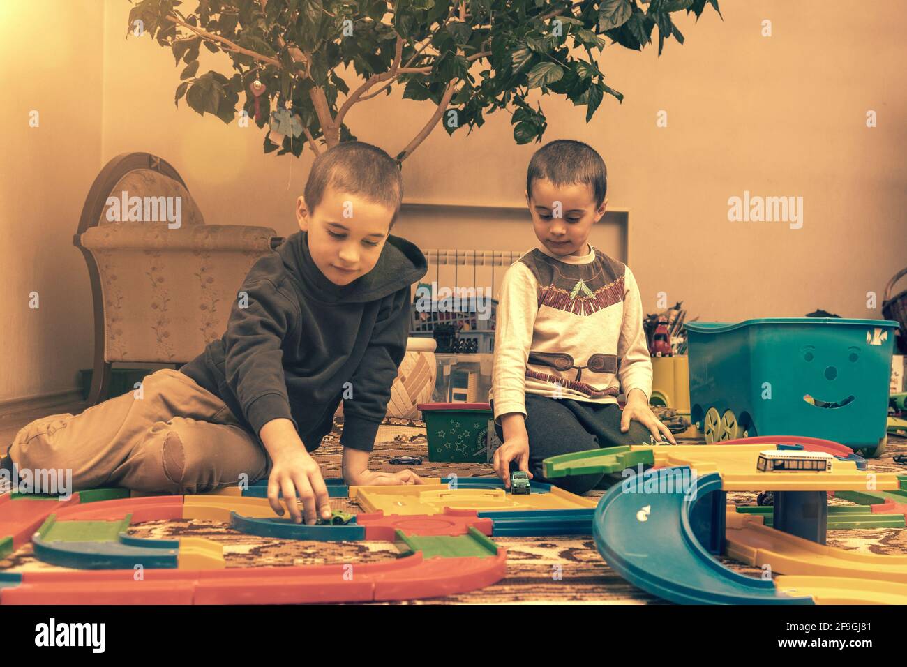 Children Boys playing with construction set on the floor.Educational games for kids. Boys playing whit blocks. Kindergarten. toned Stock Photo