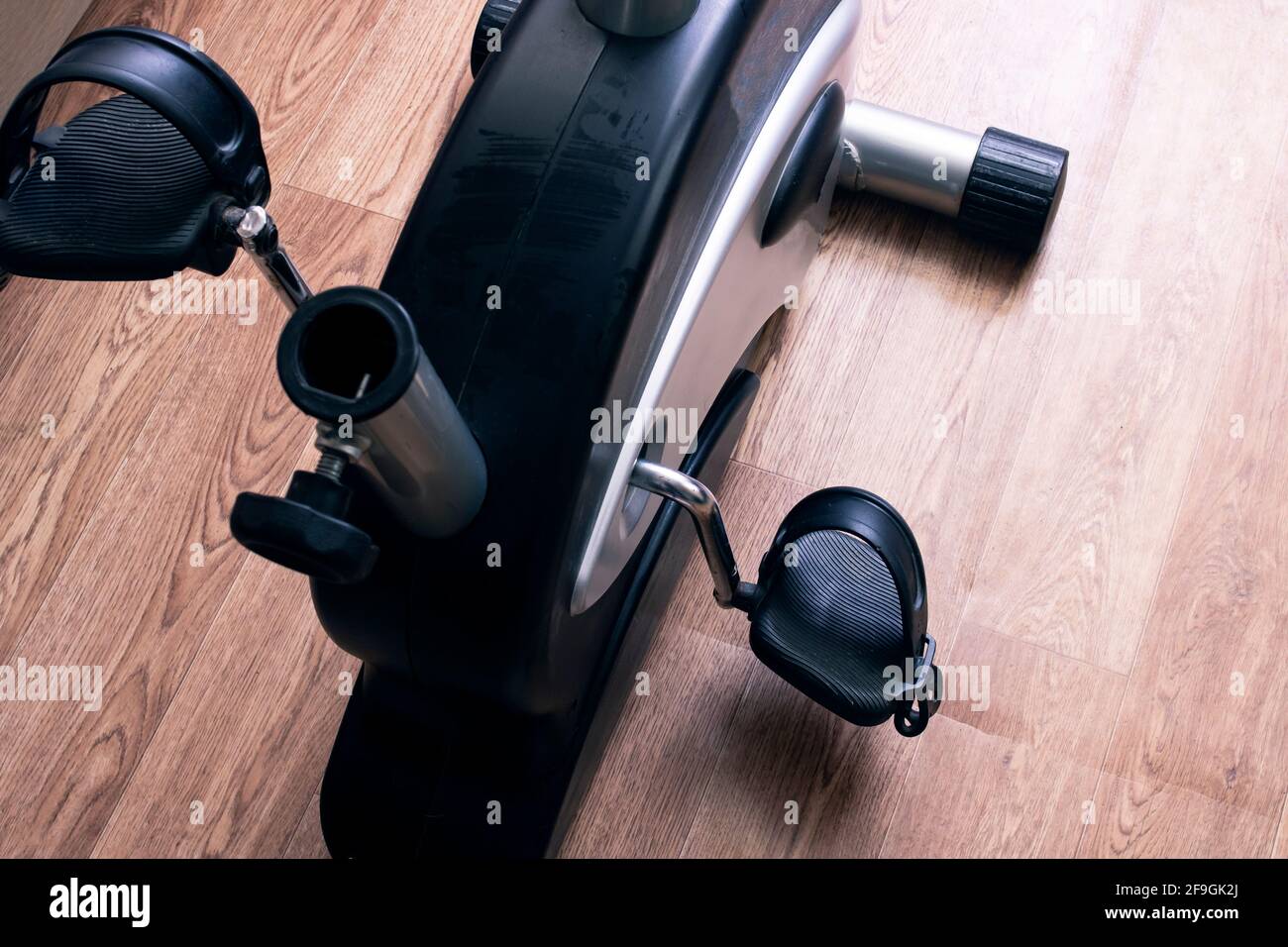 Exercise bike pedals on wood floor background close up Stock Photo