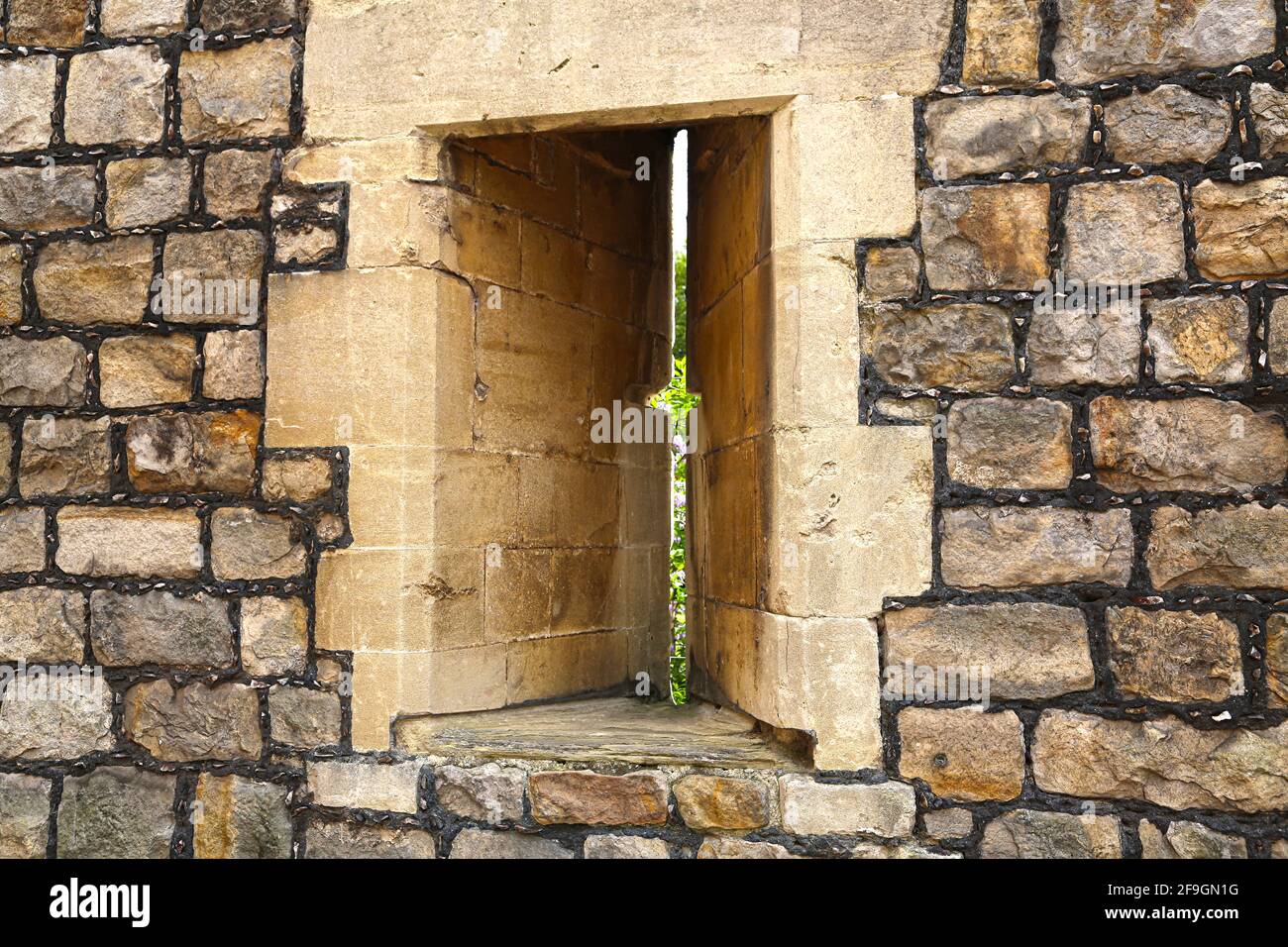 Arrow slit window vertical aperture in a fortification walls at Windsor Castle. Stock Photo