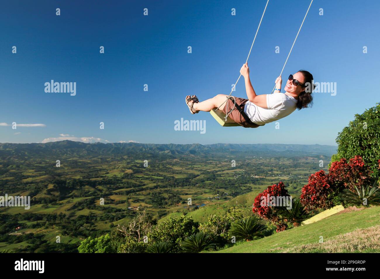 Young European woman swinging on a swing at Montana Redonda. Dominican Republic Stock Photo