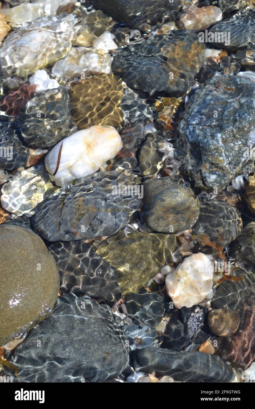 Rocks in Rock Pool, Sea Water Ripples White Grey Brown Stones Seashore, Granite, Basalt, Limestone, Sandstone, Quartz, Beach - Fuengirola, Spain. Stock Photo