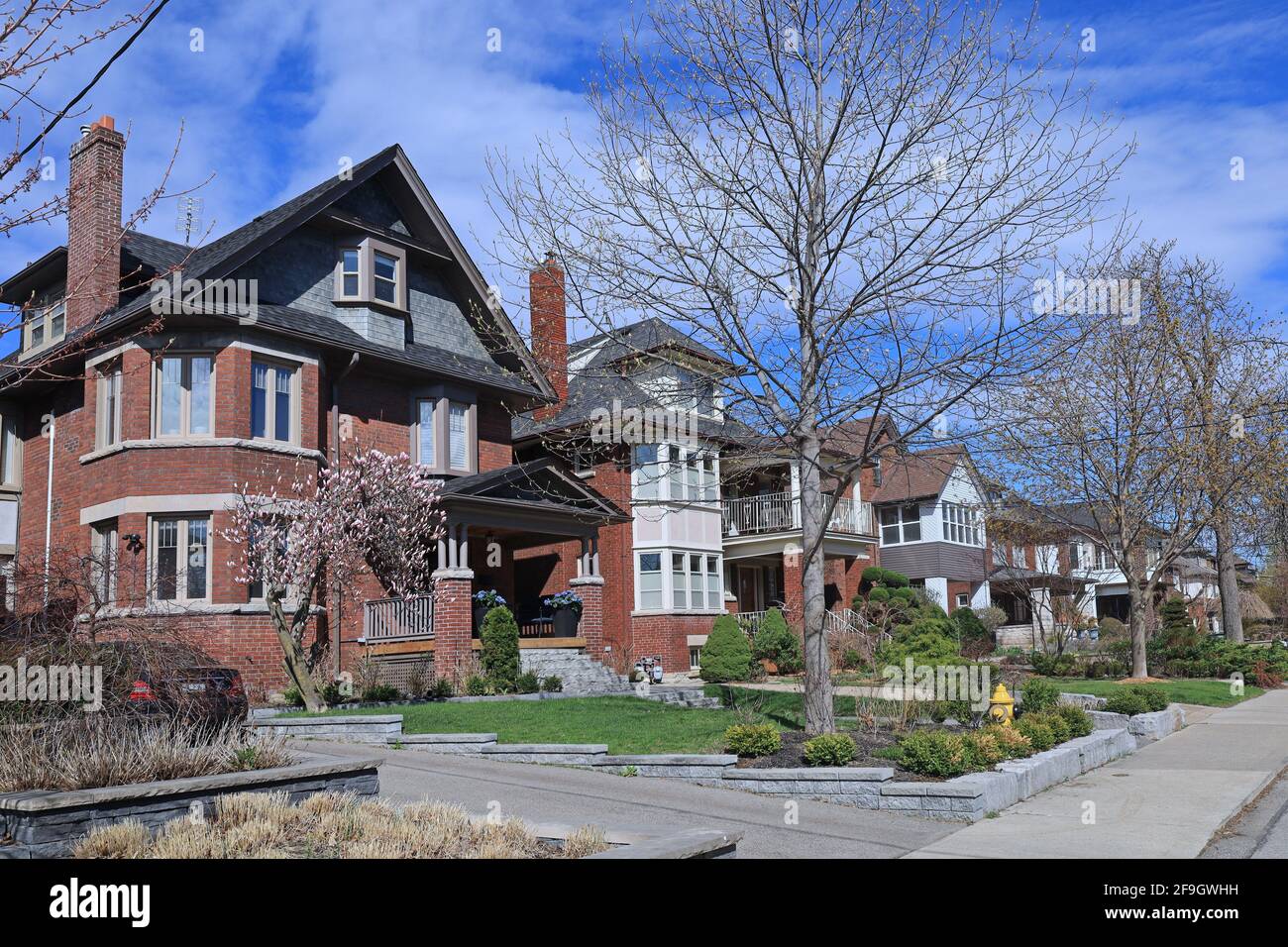 Street with row of large older brick detached houses with gables Stock ...