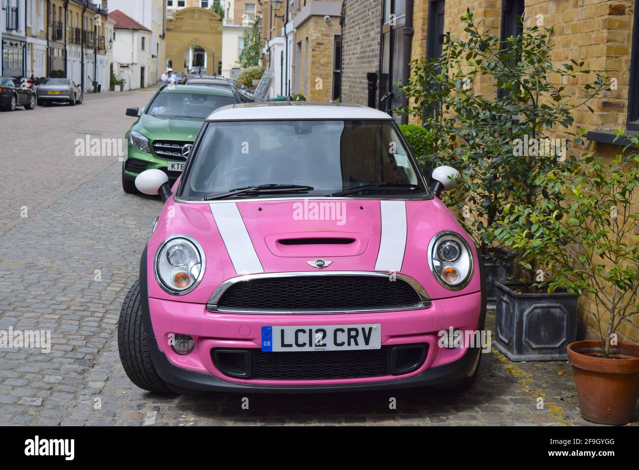 Pink car Mini parked on London street UK. Stock Photo
