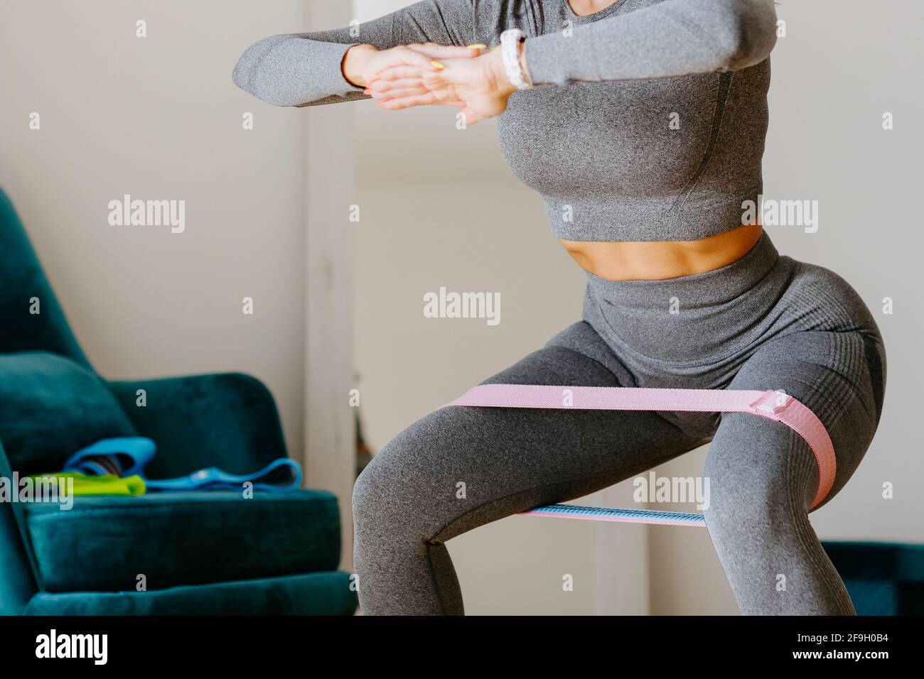 female butt workout at home squats with resistance band Stock Photo - Alamy