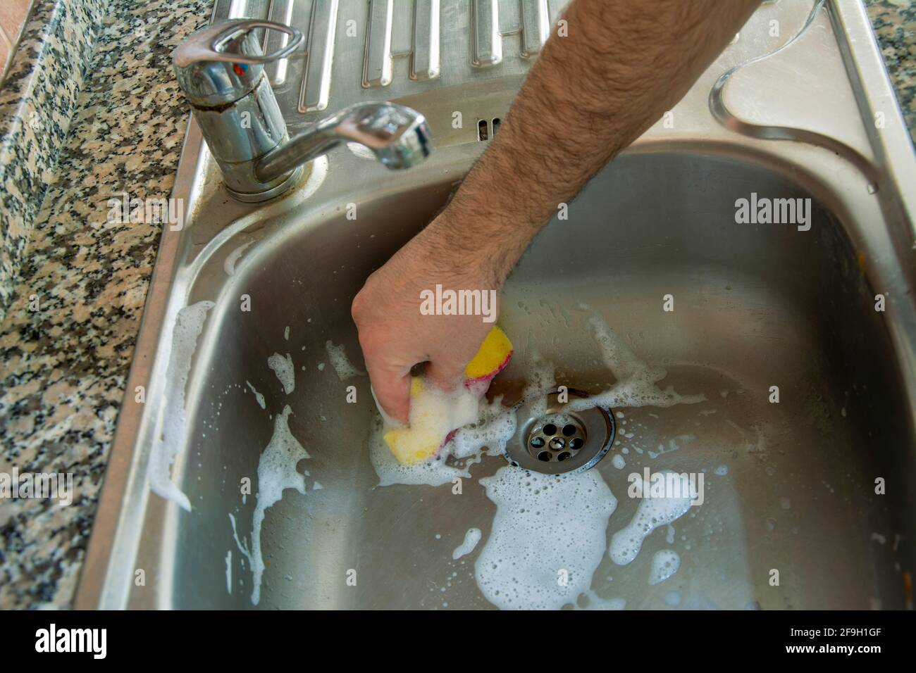 Cleaning the dirty sink with a sponge Stock Photo