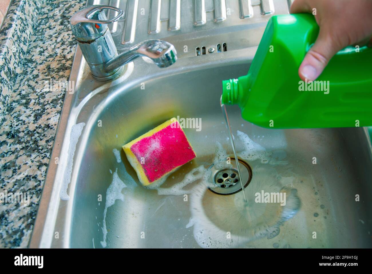 Using bleach to clean the dirty sink Stock Photo