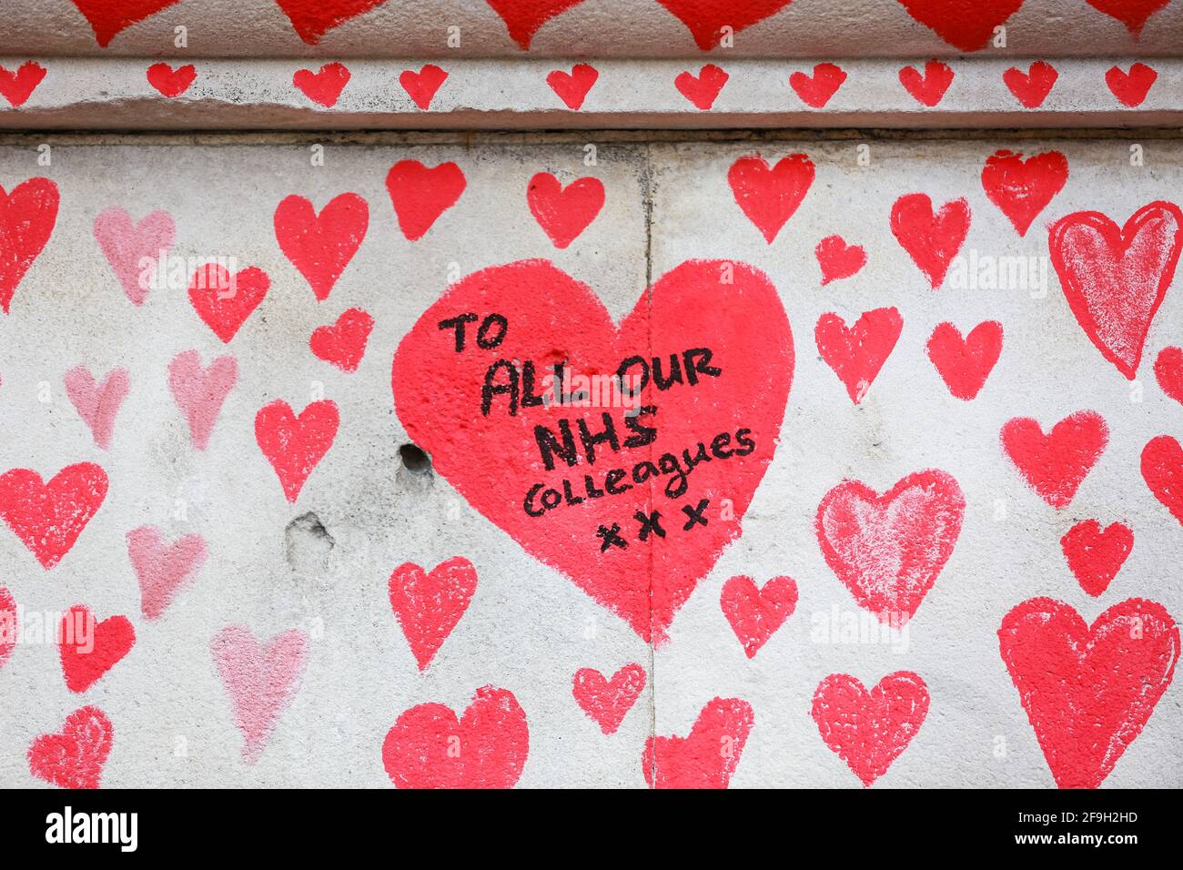 London, UK. 13 April 2021. The National COVID Memorial Wall - hand drawn red hearts on a wall opposite Houses of Parliament. Credit: Waldemar Sikora Stock Photo