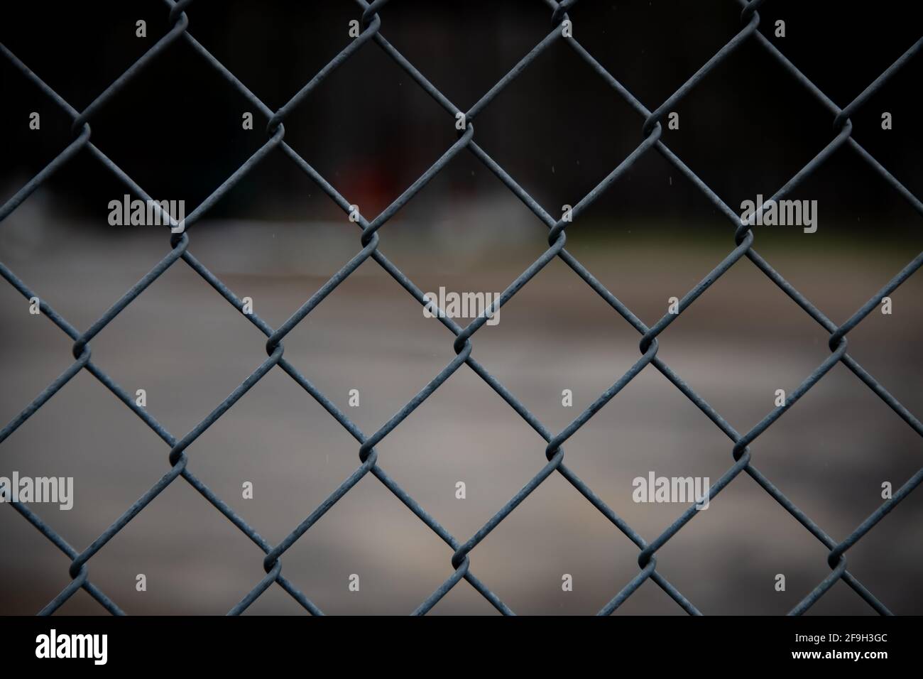 Chain link fence surrounding a dark restricted area in Speculator, NY USA Stock Photo