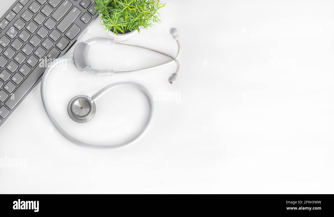 Business work place with laptop, keyboard, stethoscope and plant Stock Photo