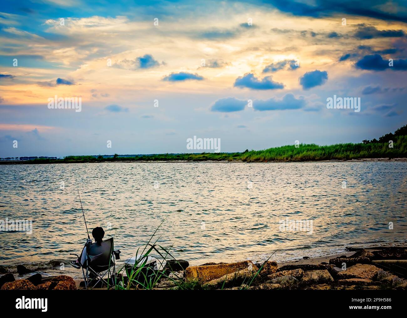A man fishes at sunset, July 7, 2012, in Bayou La Batre, Alabama. Stock Photo