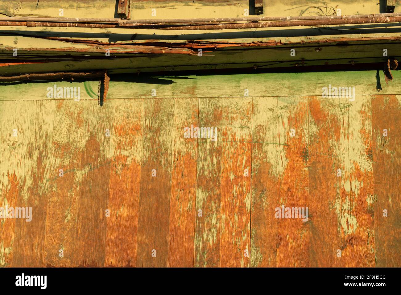 A loading dock door of an abandoned building shows its age as green paint fades. Stock Photo