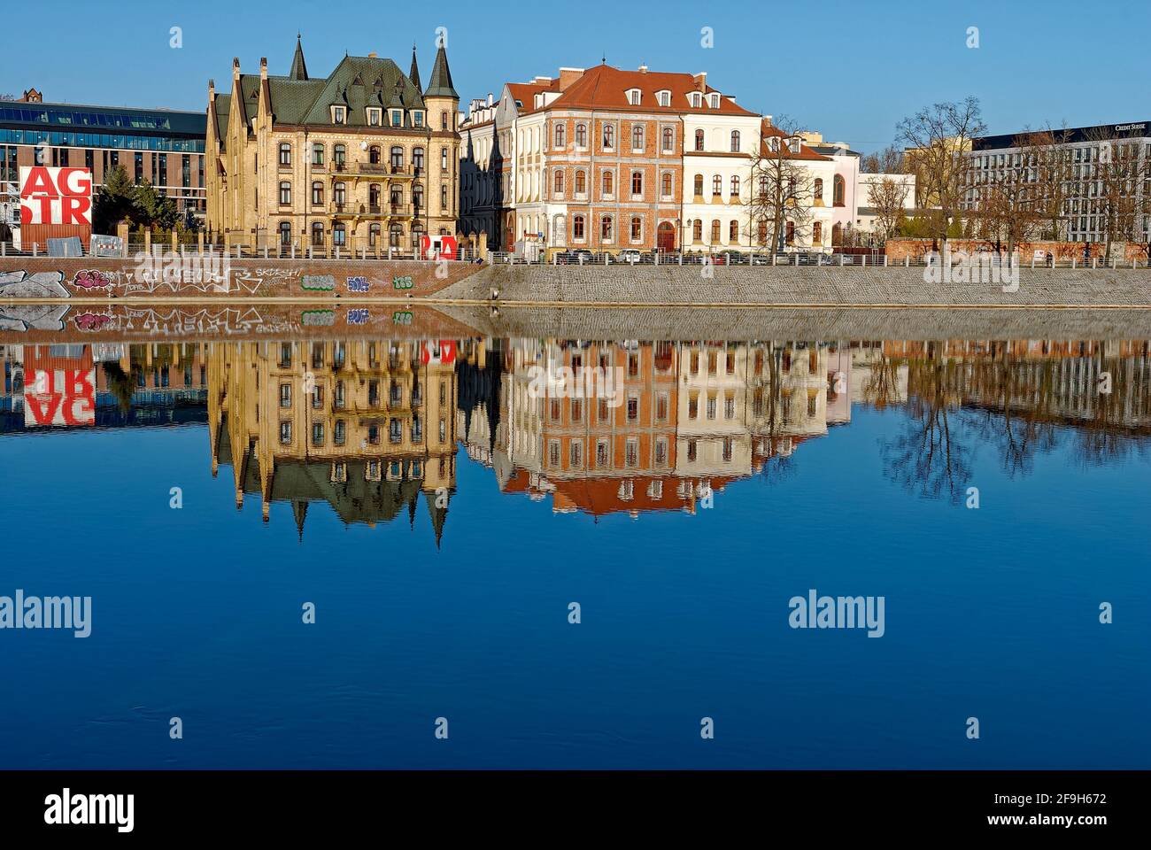 Harbor in Ostrow Tumski - embankment Oder river. Reflection of Ostrow Tumski in the Oder River. Stock Photo