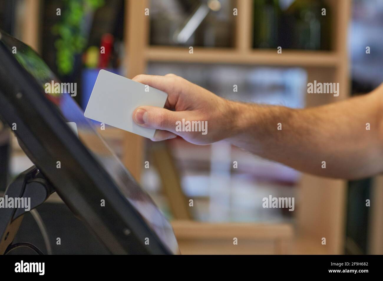 Closeup of unrecognizable man using register computer in cafe while ...