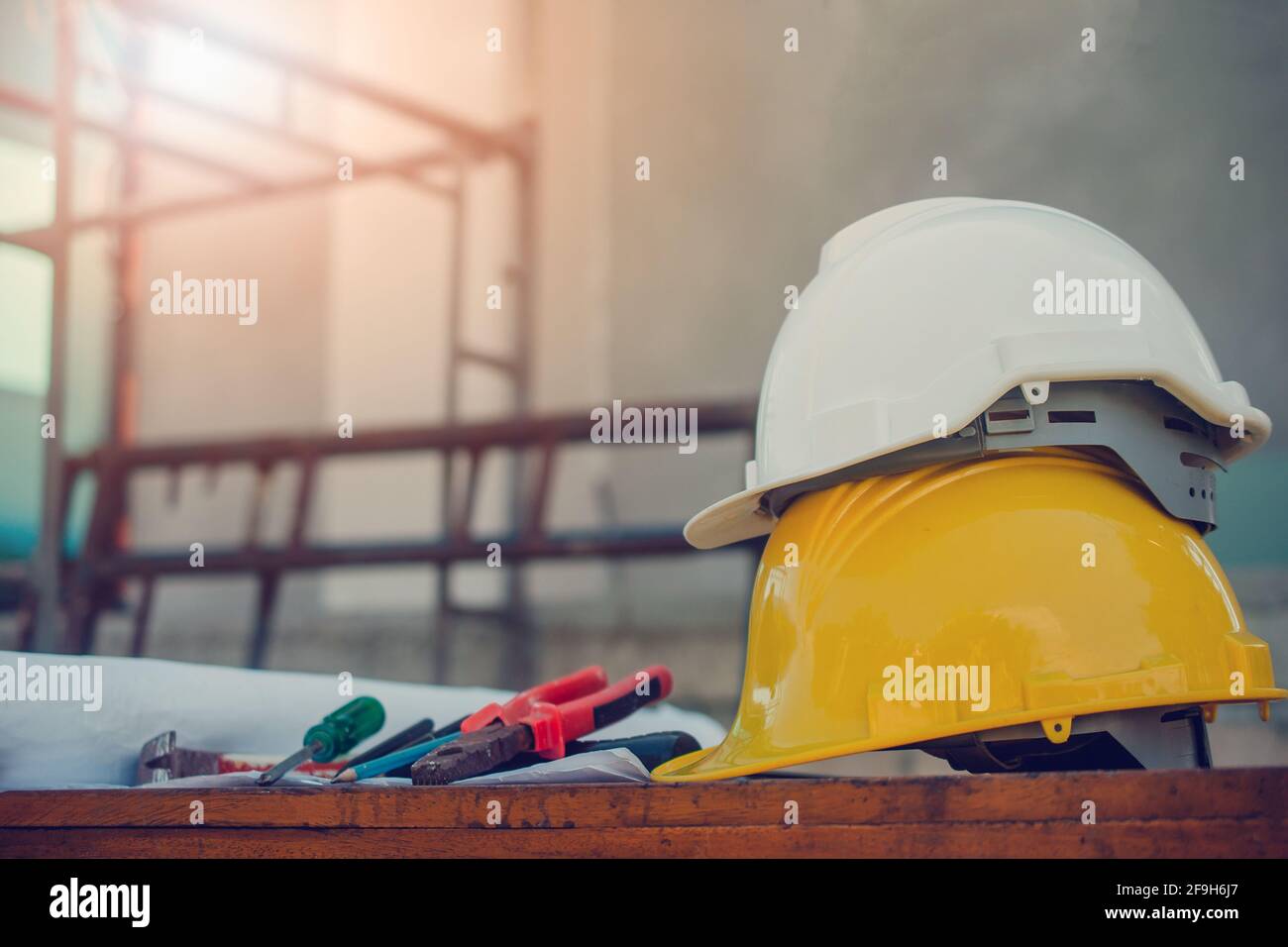 White hard hat on Yellow hard hat construction site background Stock