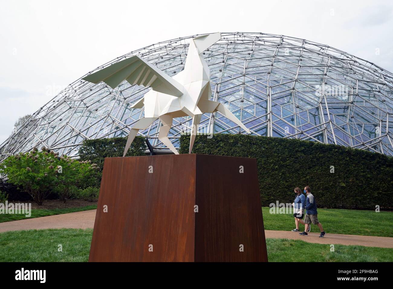 St. Louis, United States. 18th Apr, 2021. Visitors walk past the Hero's Horse Sculpture near the Climatron at the Missouri Botanical Gardens, in St. Louis on Sunday, April 18, 2021. The sculpture is one of 18 created by artist Kevin Box of Santa Fe and his Origami In The Garden features large scale installations depicting birds, ponies, boats, cranes and butterflies on display until October. Photo by Bill Greenblatt/UPI Credit: UPI/Alamy Live News Stock Photo