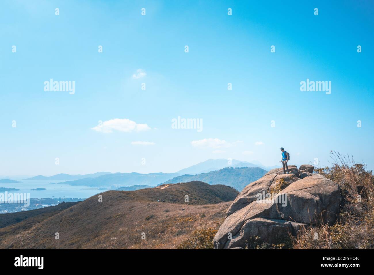 Claim Backpack Hiker standing on mountain, Lantau Island, Hong Kong, outdoor, daytime Stock Photo