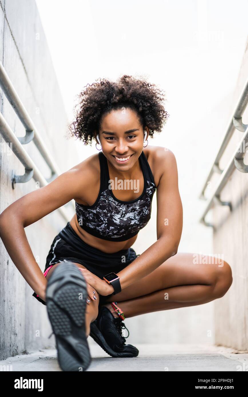 Afro athlete woman stretching legs before exercise. Stock Photo