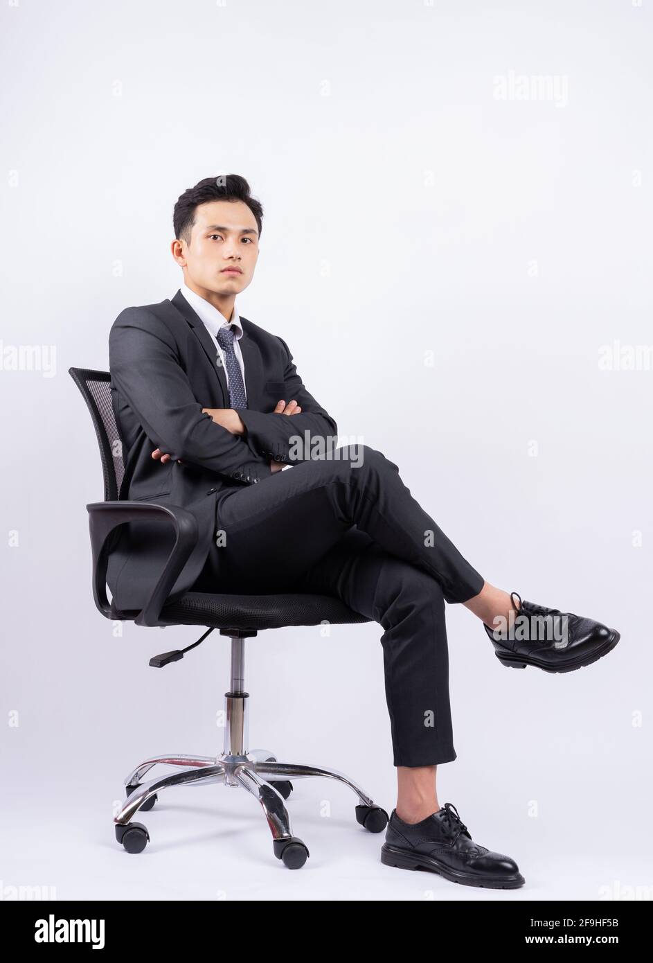 Young Asian businessman sitting on chair on white background Stock ...