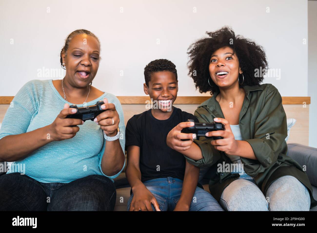 Grandmother, mother and son playing video games at home Stock Photo - Alamy