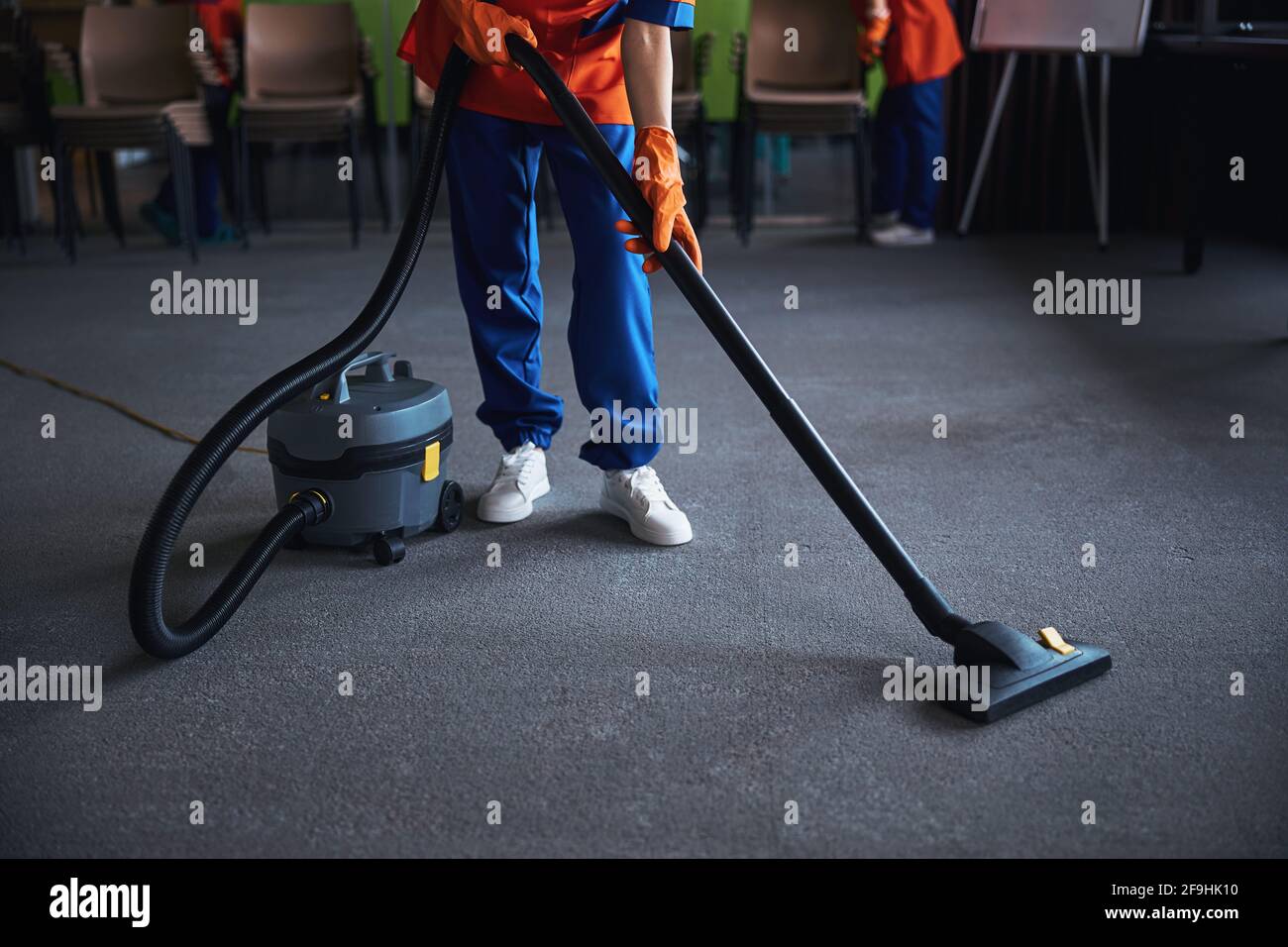 Cleaning lady using a canister vacuum cleaner Stock Photo