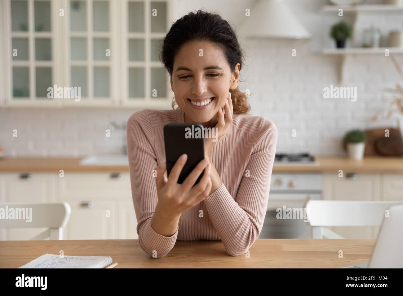 Cheerful latina woman spend time at social network using phone Stock Photo