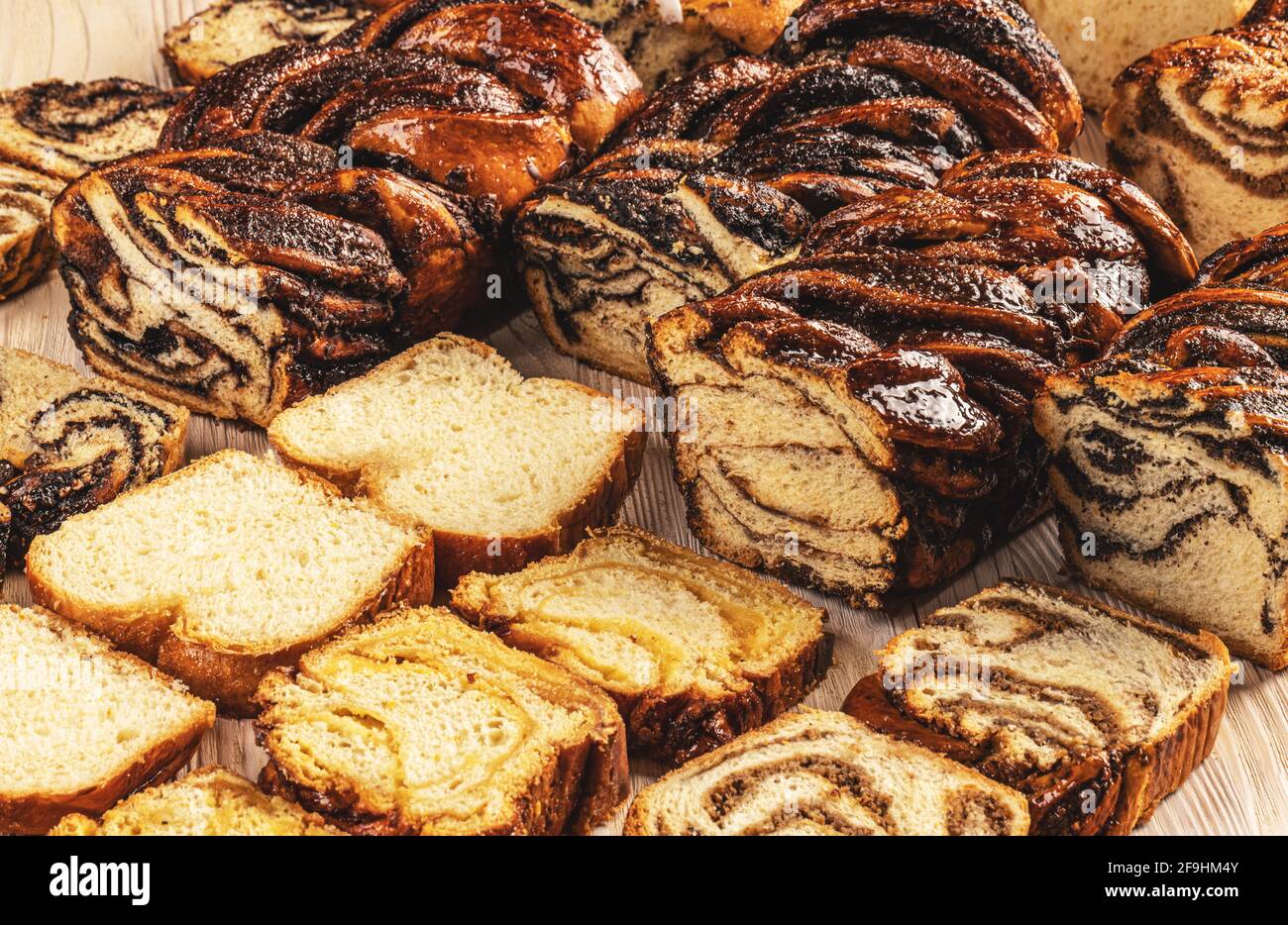 Different type of babka or brioche bread. Stuffed with chocolate, poppy seeds, walnuts, almond Stock Photo