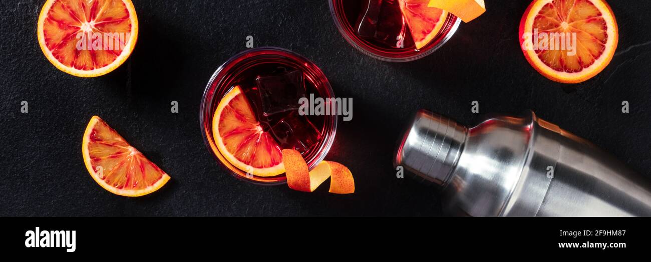 Negroni cocktails panorama with blood oranges on black Stock Photo