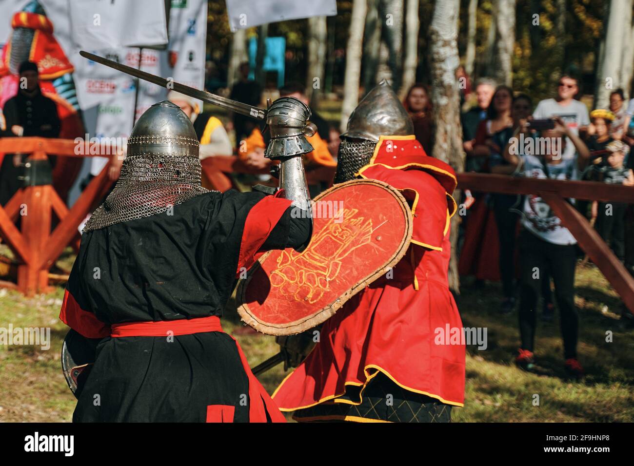 Knights fight with swords and shields in front of the public