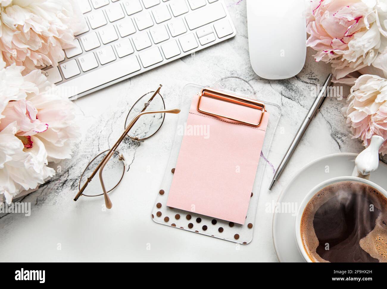 Flat lay top view women's office desk with flowers. Female workspace