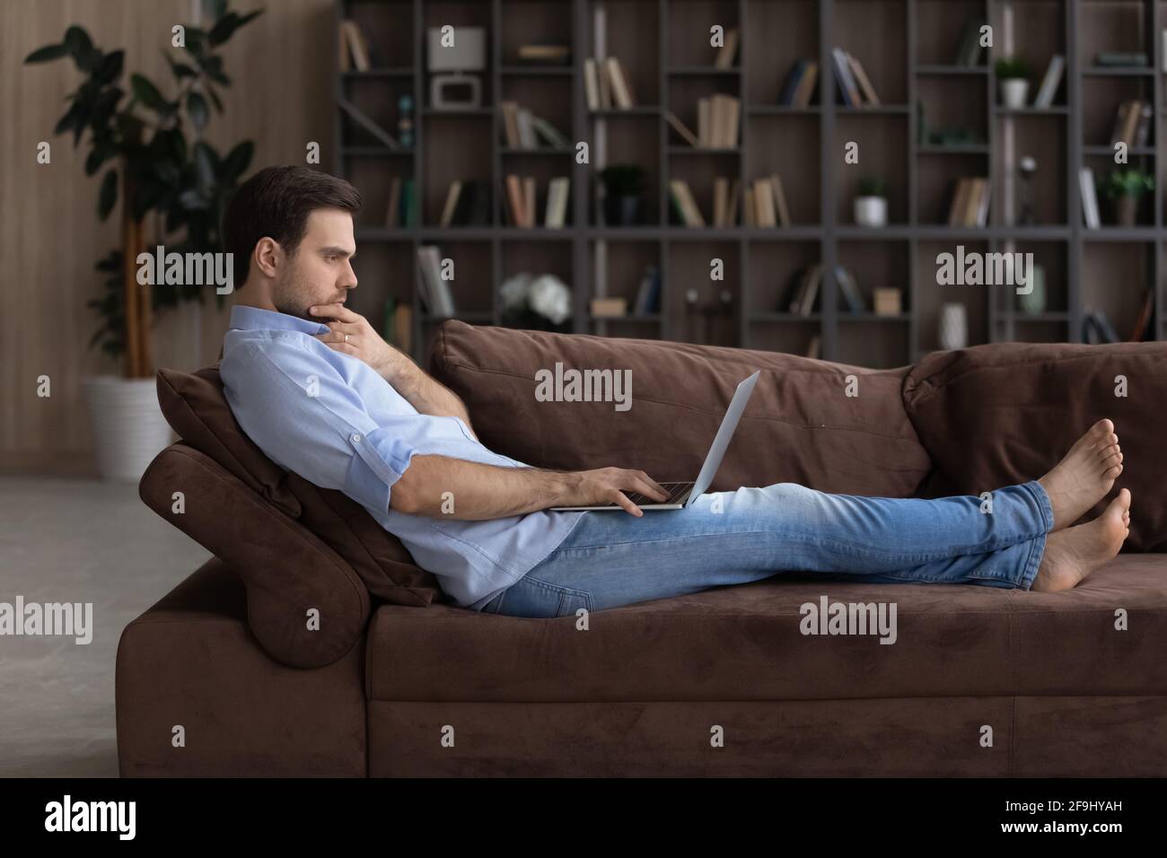 Pensive man look at laptop screen making decision Stock Photo