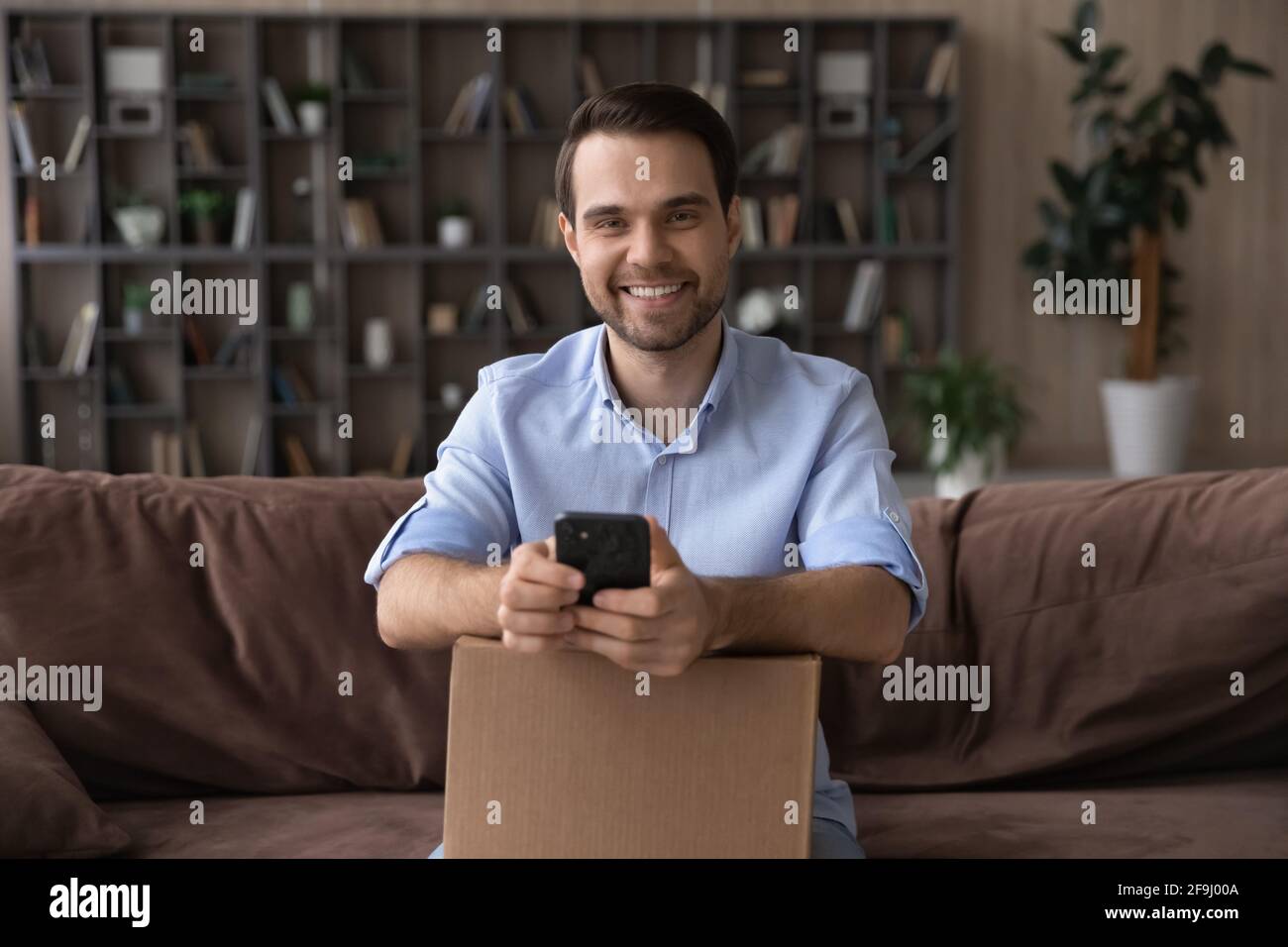 Portrait of smiling male buyer track order on cell Stock Photo