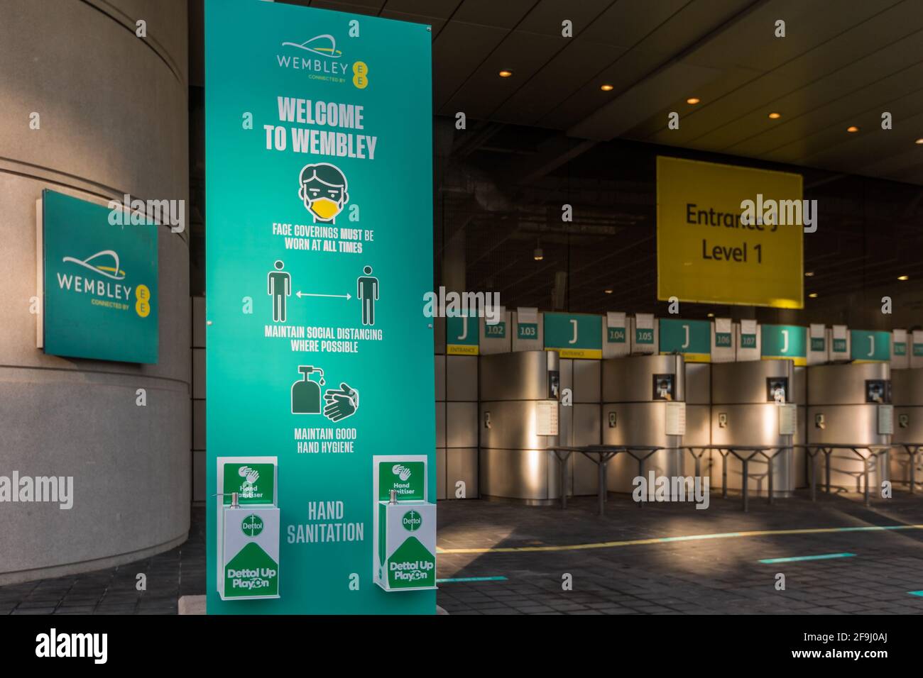 Wembley Park, London, UK. 19th April 2021.  Covid safety measures in place at Wembley Stadium turnstiles. Hand sanitising stations and 2 metre social distancing signs and floor markers can be seen around the concourse.  The National Stadium is hosting 3 pilot events (The Carabao and FA Cup Finals and an Emirates FA Cup Semi-Final) as part of the government’s science-led Events Research Programme (ERP) to get big crowds back this summer. Amanda Rose/Alamy Live News Stock Photo