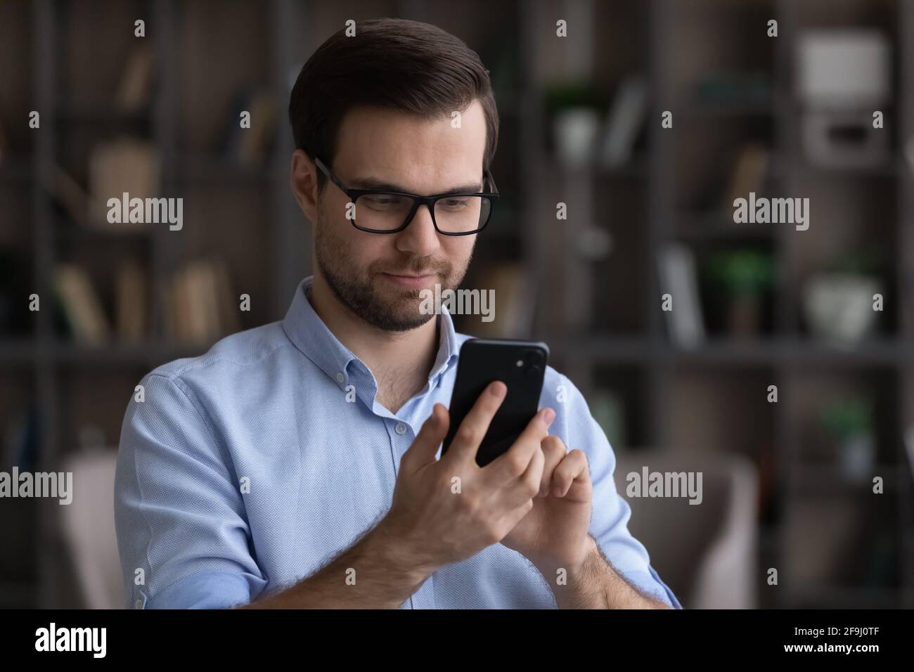 Millennial man use smartphone texting online on gadget Stock Photo