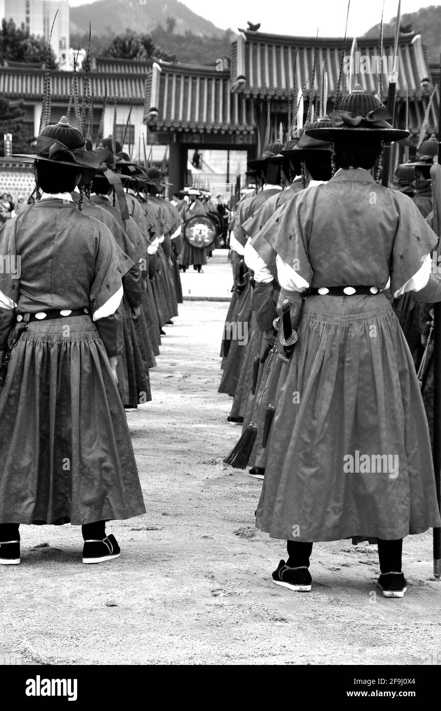 Vertical shot of men in traditional costumes in grayscale Stock Photo