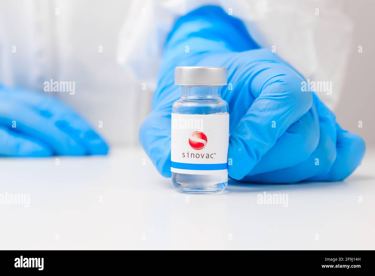 Sinovac vial or bottle with pharmaceuticals demonstrated by health worker or scientist in rubber gloves, April 2021, San Francisco, USA  Stock Photo