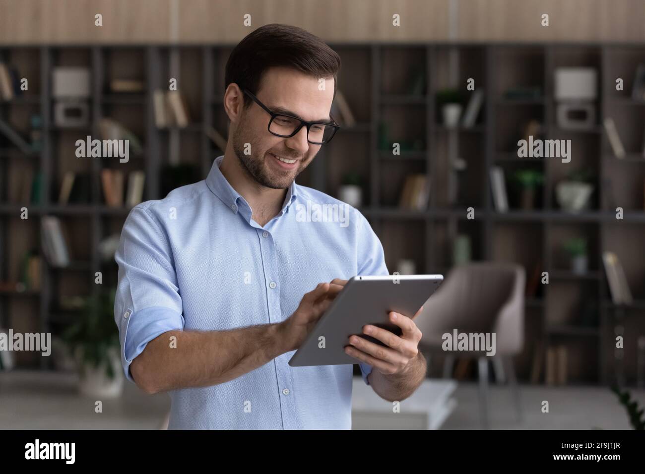 Smiling young man use modern tablet texting Stock Photo