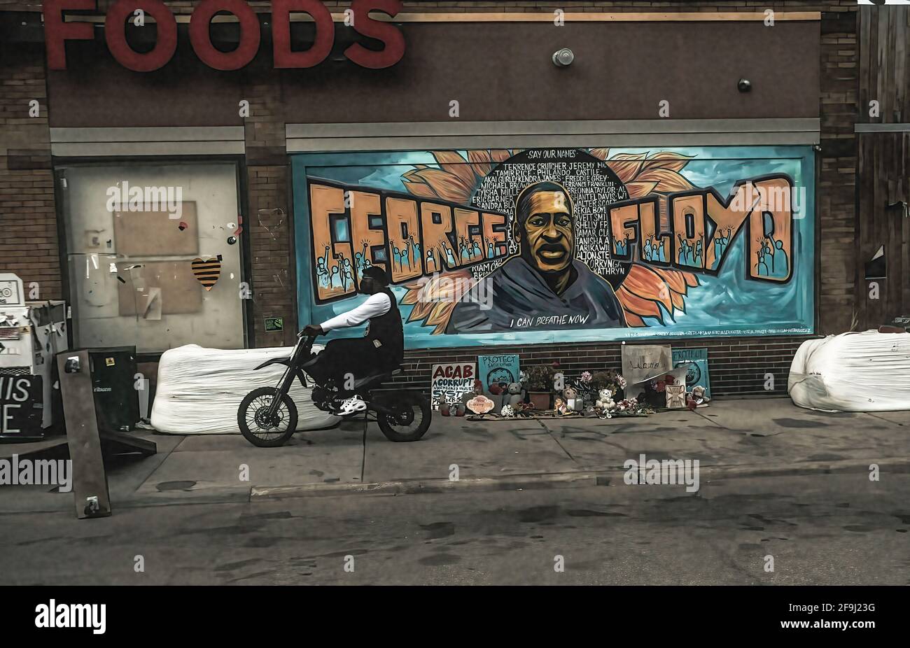 Minneapolis, United States. 18th Apr, 2021. A man pays respect to a mural of George Floyd by the Cup Foods where he was killed by Minneapolis Police Officer Derek Chauvin in Minneapolis, Minnesota. On the night before closing statements are set to be delivered in the trial of former Minneapolis Police Officer Derek Chauvin over the killing of George Floyd, a crowd congregated at George Floyd Plaza where relatives of black men killed by police delivered speeches and made statements. Credit: SOPA Images Limited/Alamy Live News Stock Photo