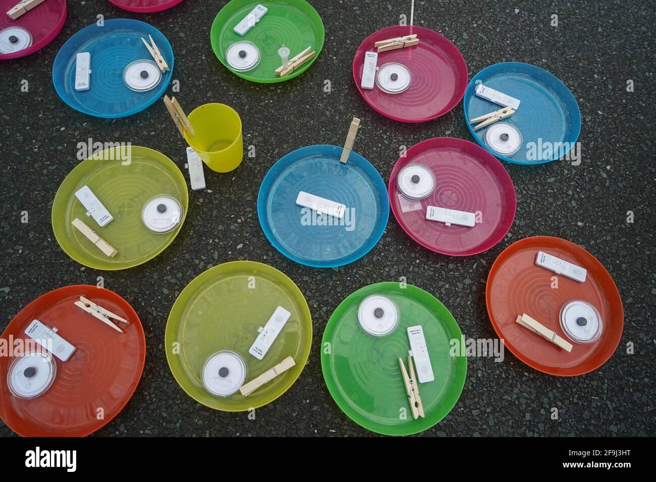 Berlin, Germany. 19th Apr, 2021. The finished Corona self-tests of some pupils of the Fritz-Karsen-Gemeinschaftsschule lie next to each other on colourful plates. The children of Berlin have to be tested for the corona virus in schools starting today. Credit: Jörg Carstensen/dpa/Alamy Live News Stock Photo