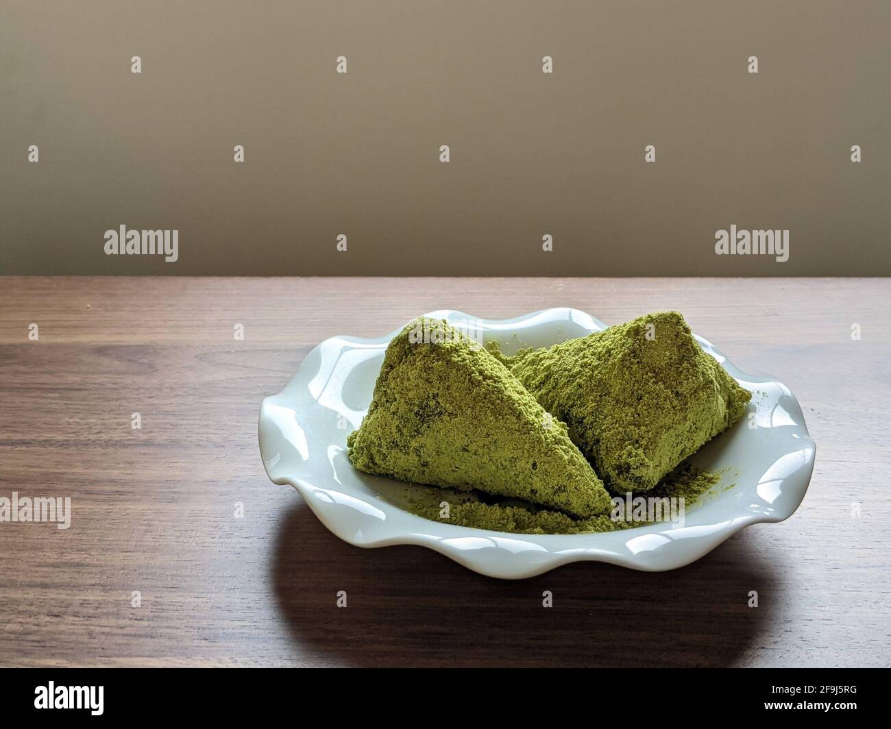 Green Soybean Flour seasoned Sticky Rice Rolled with Bamboo Grass Stock Photo