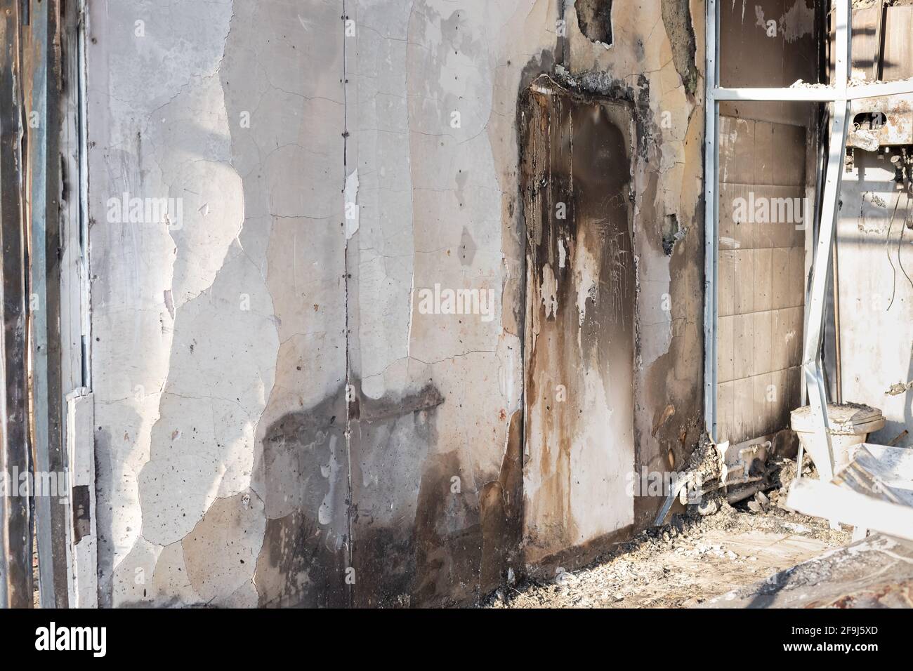 damaged wall with traces of burning and black soot in building after fire. arson investigation. horizontal image. side view. Stock Photo