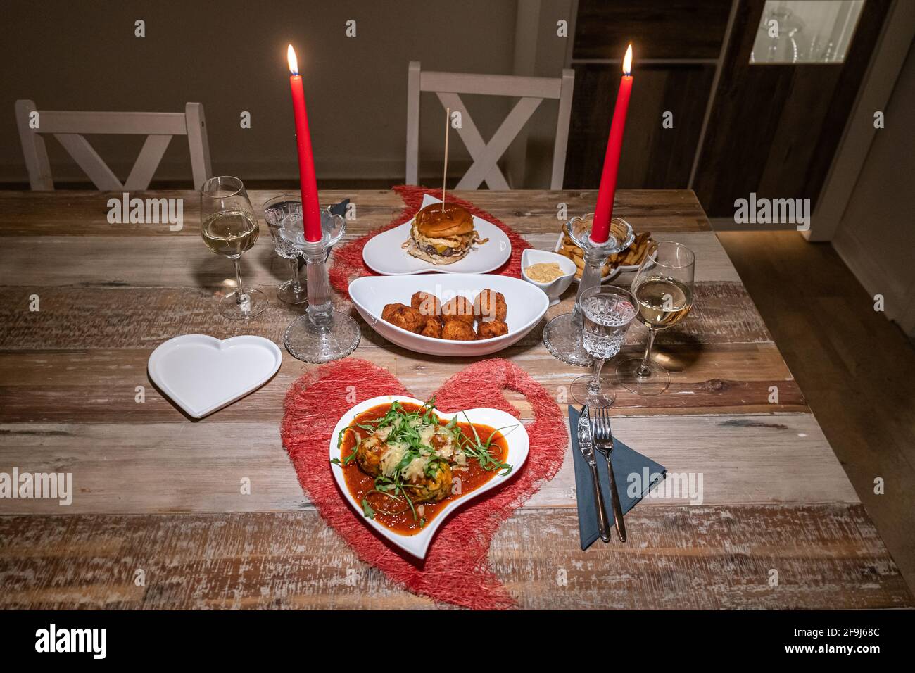 Valentines day dinner setting romantic love for two wooden table red heart  shape candle light with Burger and Pasta Stock Photo - Alamy